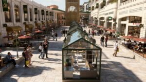 Open-air shopping promenade with glass-roofed kiosks along a central walkway and outdoor cafes with red umbrellas on both sides, crowds strolling and chatting.