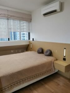 Bedroom with a low platform bed, beige quilt, two round gray cushions, and built-in floating nightstands on either side of the bed.