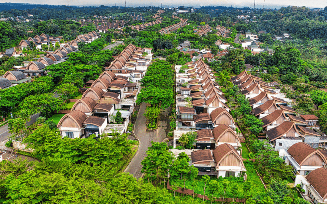 Aerial view of a lush, planned community with rows of arched-roof villas and tree-lined streets.