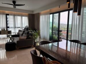 Modern open-plan living area with a gray sofa, marble dining table, and a balcony view through sheer curtains.