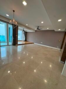 Spacious modern living area with shiny beige tile floor, recessed lights, chandelier, and two ceiling fans; sliding doors to a balcony on the left.