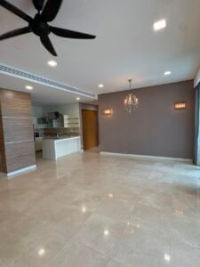 Open-concept living space with a marble kitchen island, beige tile floor, and a taupe accent wall with a chandelier.