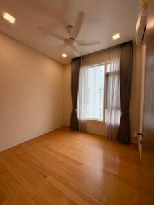 Empty room with light wood floor, large window with sheer and dark curtains, ceiling fan, and wall-mounted AC nearby.