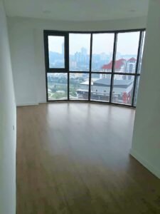 Empty, unfurnished room with a curved wall of floor-to-ceiling windows offering a city skyline view.