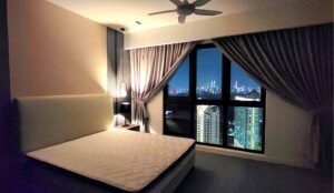 Bedroom with a queen bed, nightstand lamp, ceiling fan, and a large window showing a night city skyline.